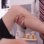 Senior caucasian doctor examining knee injury